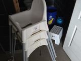 une chaise haute pour bébé dans une salle de bains, à côté des toilettes