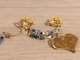 a gold leaf brooch, earrings, and bracelet on a wooden table