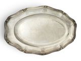 une assiette ovale en argent ornée d'un motif décoratif sur le bord