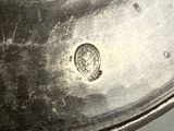 a close up of a silver plate with a coin on it
