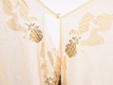 a white and gold dress hanging on a clothes line