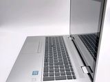 a silver laptop computer sitting on a white surface