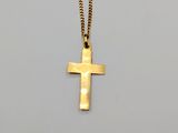 a gold cross pendant with a chain on a white background