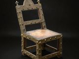 an old wooden chair with a metal frame on a black background