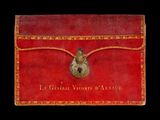 un vieux livre rouge surmonté d'un cadenas