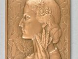 plaque en bronze représentant une femme avec une fleur dans les cheveux