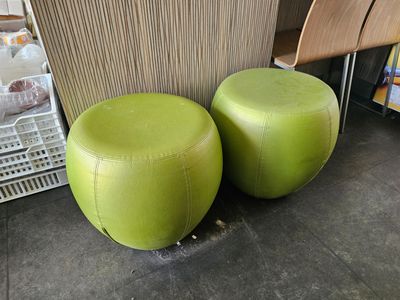 two green stools sitting next to each other on the floor