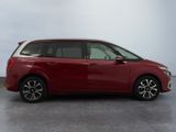 a red minivan parked in a parking lot with a sky background