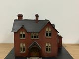 a small model of a house on a wooden table