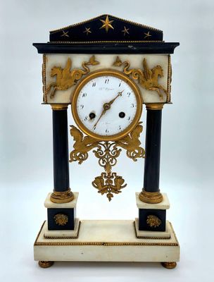 une horloge posée sur un support sur fond blanc