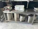 a metal table with a bunch of containers on top of it