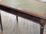 a wooden table with a green top on a wooden floor