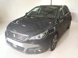 La voiture noire est garée dans une pièce blanche au sol blanc.