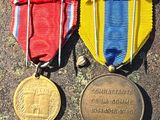 deux médailles et une autre médaille posées par terre les unes à côté des autres
