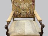 une vieille chaise dont le dossier est orné d'une tapisserie