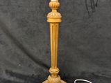 an antique brass table lamp with a white shade on top