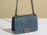 un petit sac Chanel bleu posé sur une table blanche
