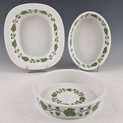 deux assiettes blanches et vertes ornées de feuilles vertes, posées sur une table