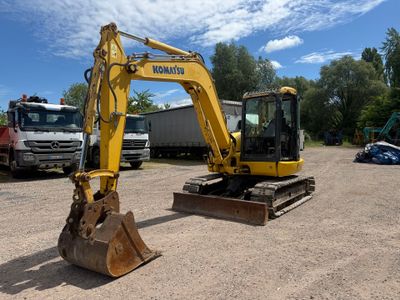une pelleteuse jaune qui est à l'arrêt dans la terre