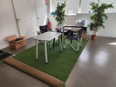 a room with a table, chairs, and a rug on the floor