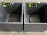 two black trash bins sitting on the floor next to each other