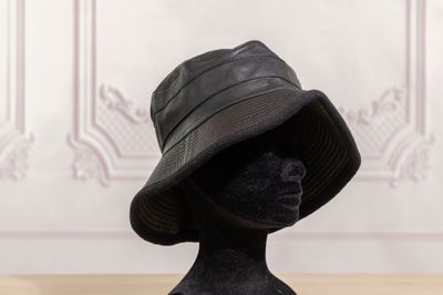 a black hat on a mannequin head on a table