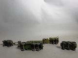 several toy army vehicles are lined up in a row on a white surface