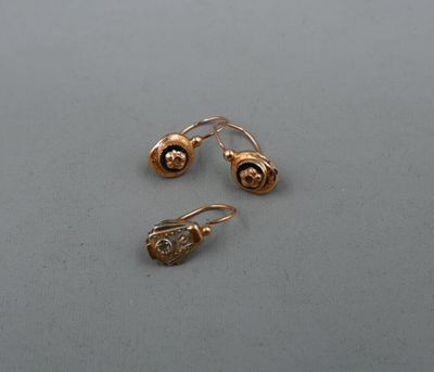 deux paires de boucles d'oreilles en or posées sur une surface grise