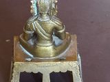 une petite statue représentant une personne assise sur une table