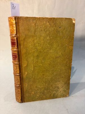 un vieux livre posé sur une table à côté d'une feuille de papier