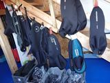 plusieurs combinaisons suspendues à un portant dans une pièce