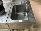 a sink in the middle of a kitchen with a pot on the counter
