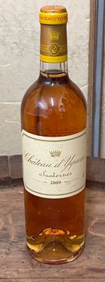 une bouteille de whisky posée sur une table à côté d'une bouteille de vin