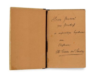 an old book with writing on it sitting open on a white surface