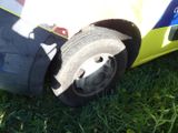 a yellow and blue car with a flat tire on the grass
