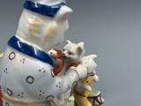 une figurine représentant un chat et un chien à cheval