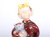 a figurine of a boy holding a teddy bear