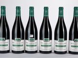 six bouteilles de vin sont alignées sur une table