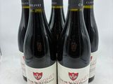 six bouteilles de vin rouge sont alignées sur une table