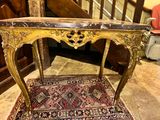 a small table with a marble top on a rug