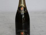 bottle of champagne sitting on a marble counter top with a white wall in the background