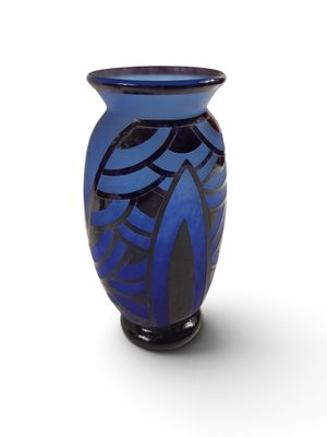 un vase bleu avec un motif sur une surface blanche