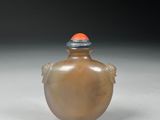an image of a brown glass snuff bottle with a red cap