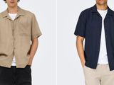 two men standing next to each other wearing shirts and pants