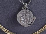 a close up of a silver coin on a gold chain