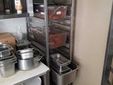 de nombreuses casseroles et poêles sur les étagères de la cuisine