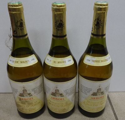three bottles of wine are lined up on a tile floor