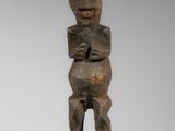 une statue en bois représentant un homme tenant un bébé dans ses bras