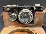 a brown leather case with a camera inside of it