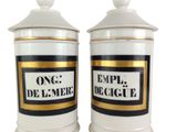 two white and gold canisters with black and white labels on them
